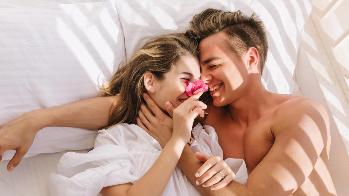 1655278945-cheerful-young-couple-love-lying-white-bed-enjoying-honeymoon-sunny-morning-smiling-hands.jpeg